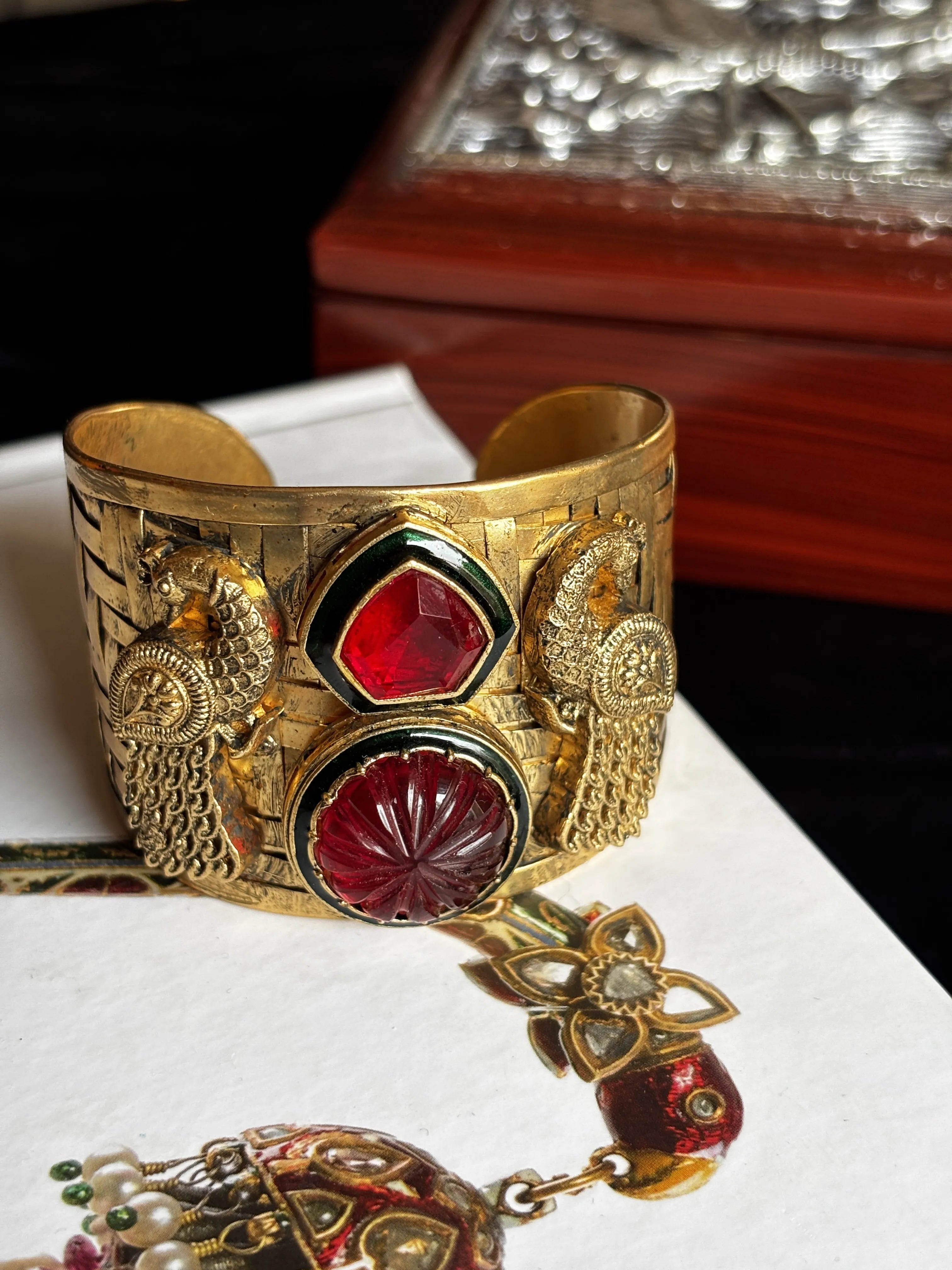 Gold bracelet with red gemstones on a white background