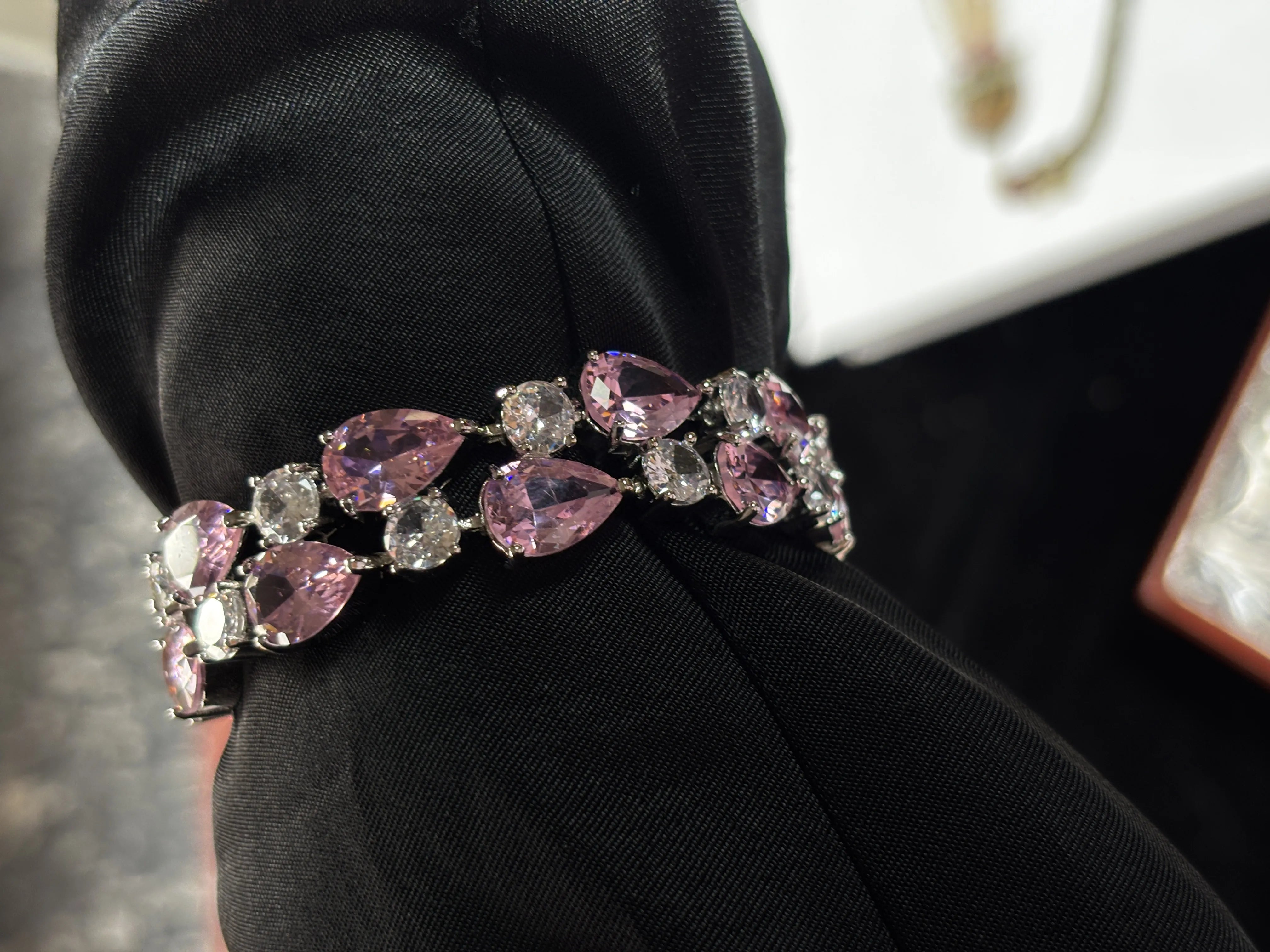 Bracelet with pink and clear gemstones on a black surface