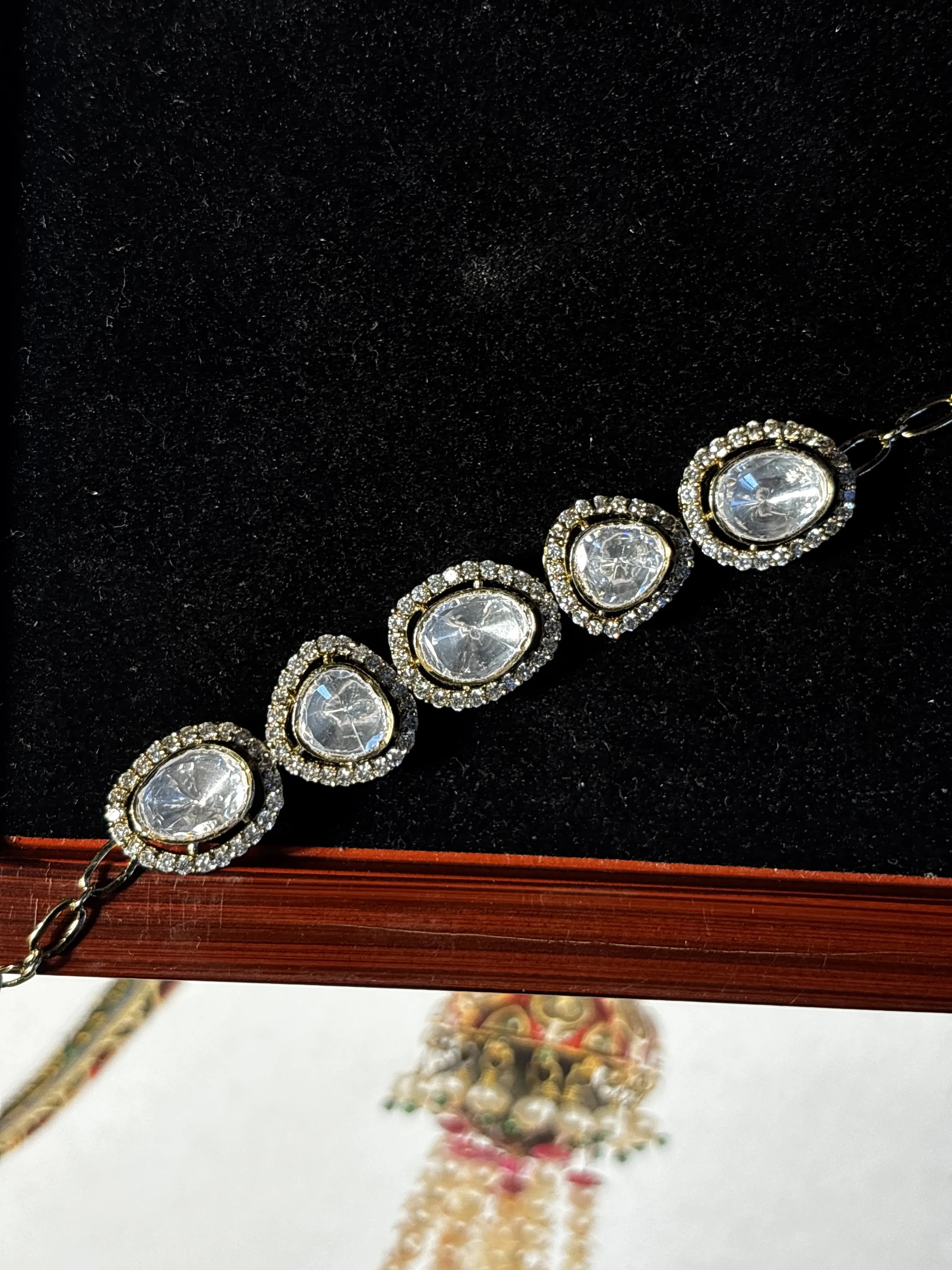 Silver bracelet with clear stones on a black background