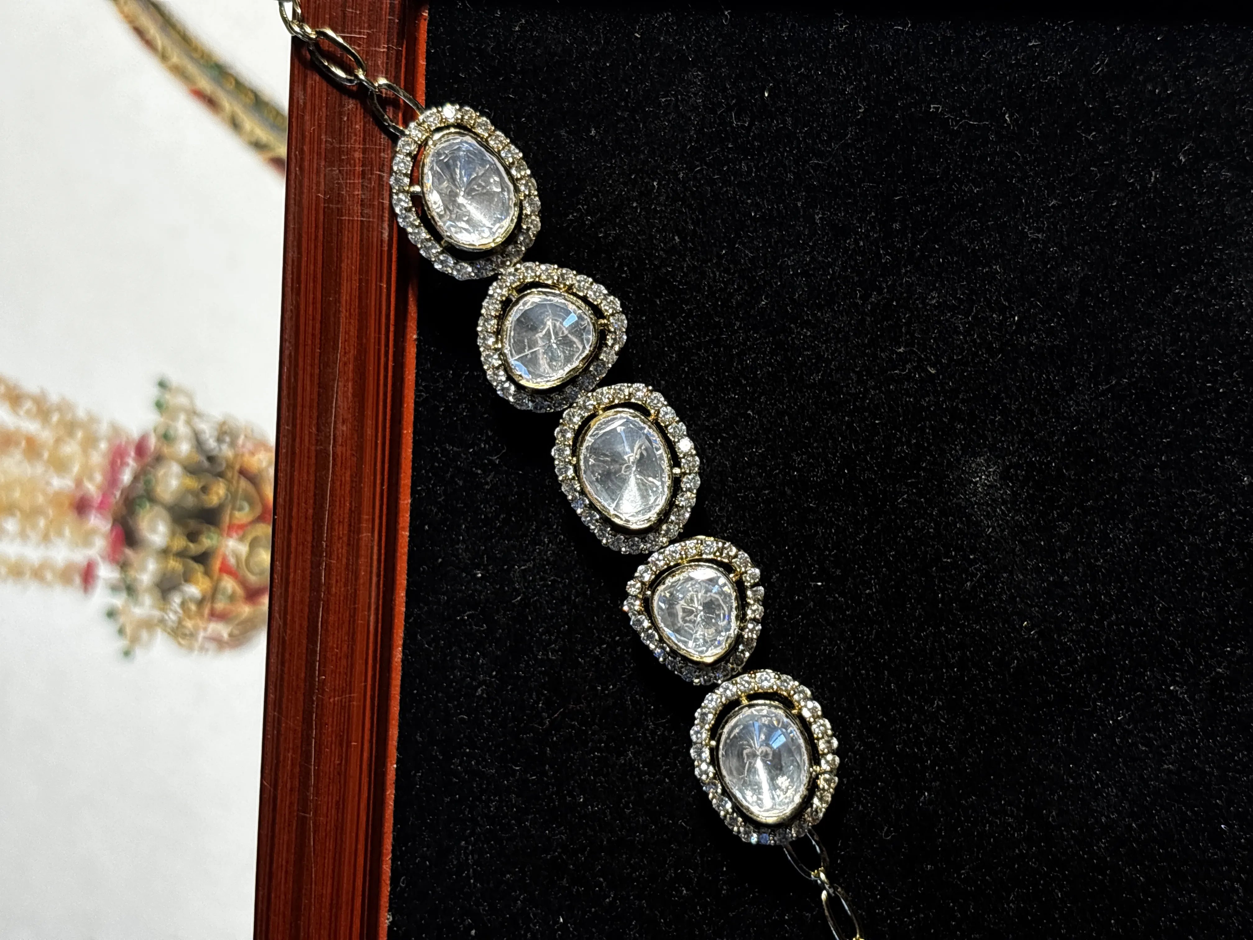 Silver bracelet with clear stones on a black background