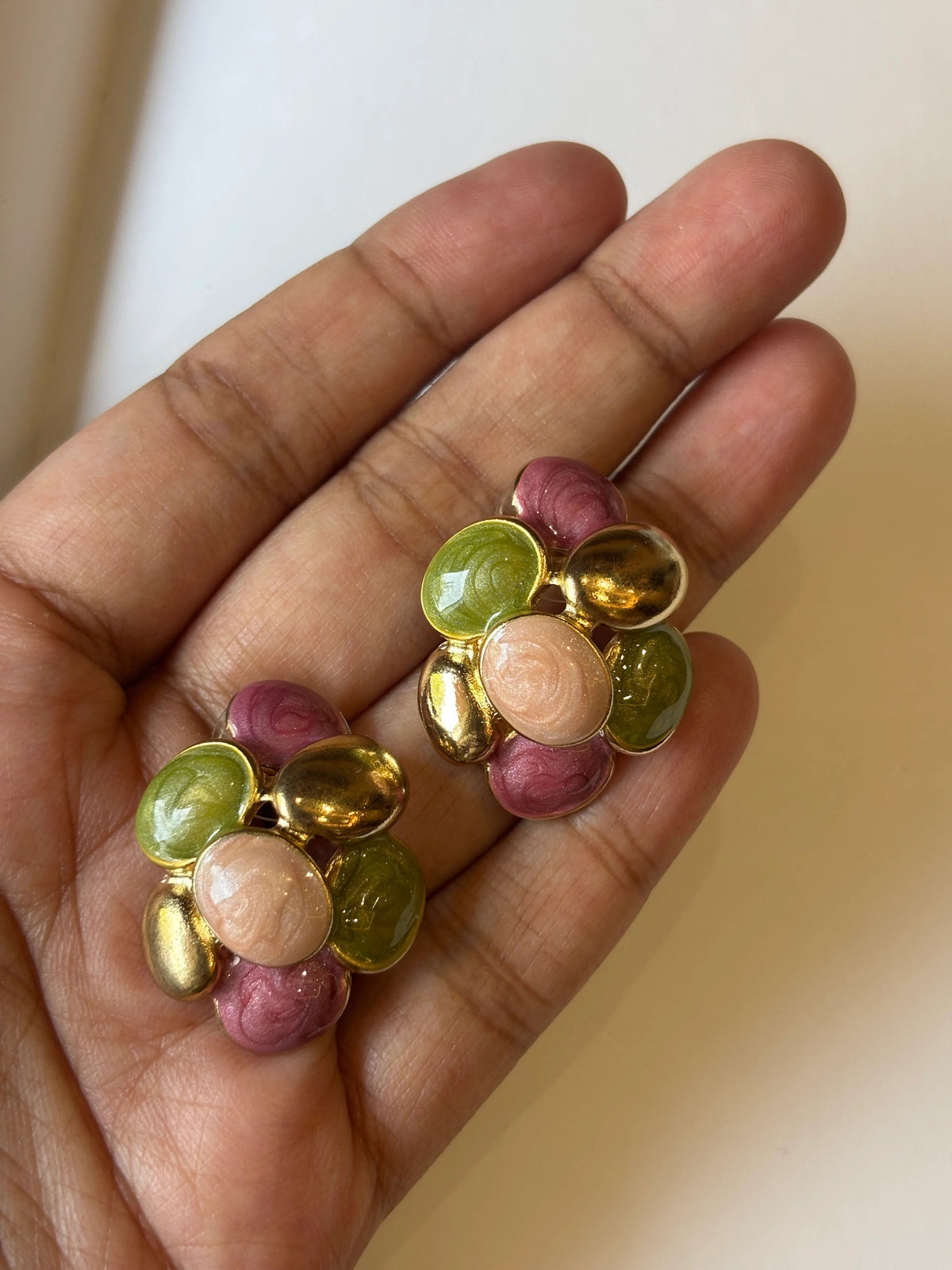 Hand holding colorful round beads against a neutral background