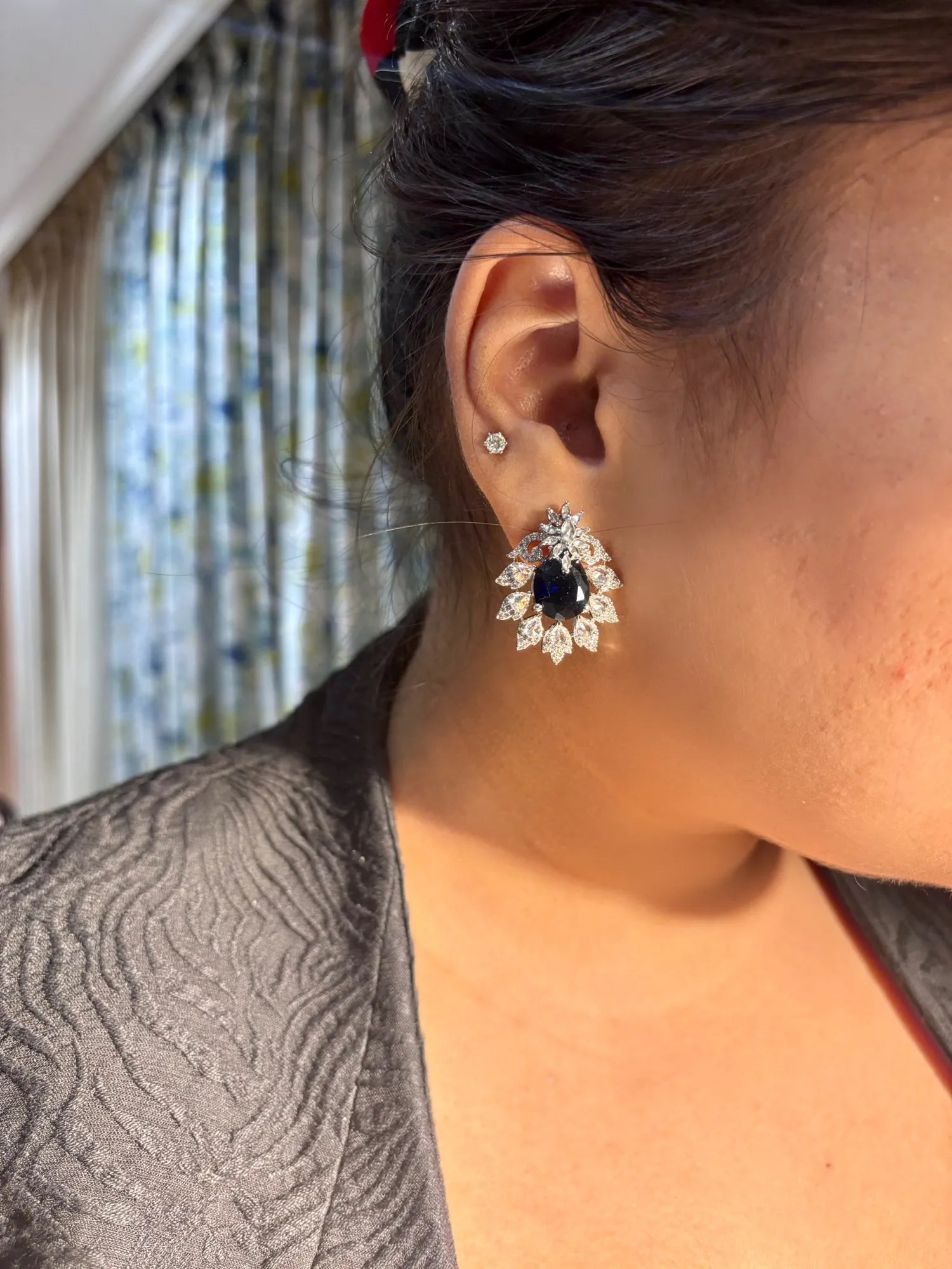 Close-up of an earring worn by a person with a blurred background